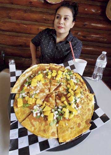 Woman Holding Large Quesa Pizza